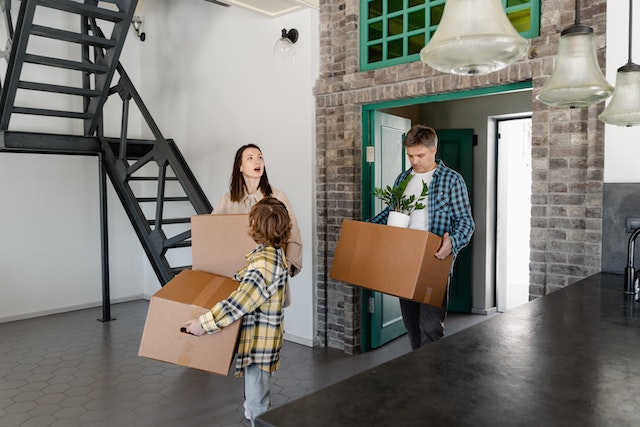 family-of-3-walking-into-a-home-with-boxes